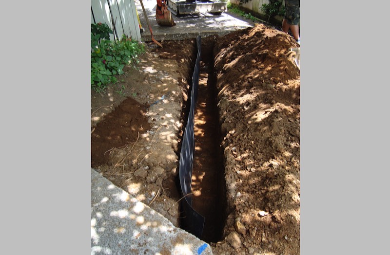 Installation of root barrier, to isolate tree roots from underground services or paving.